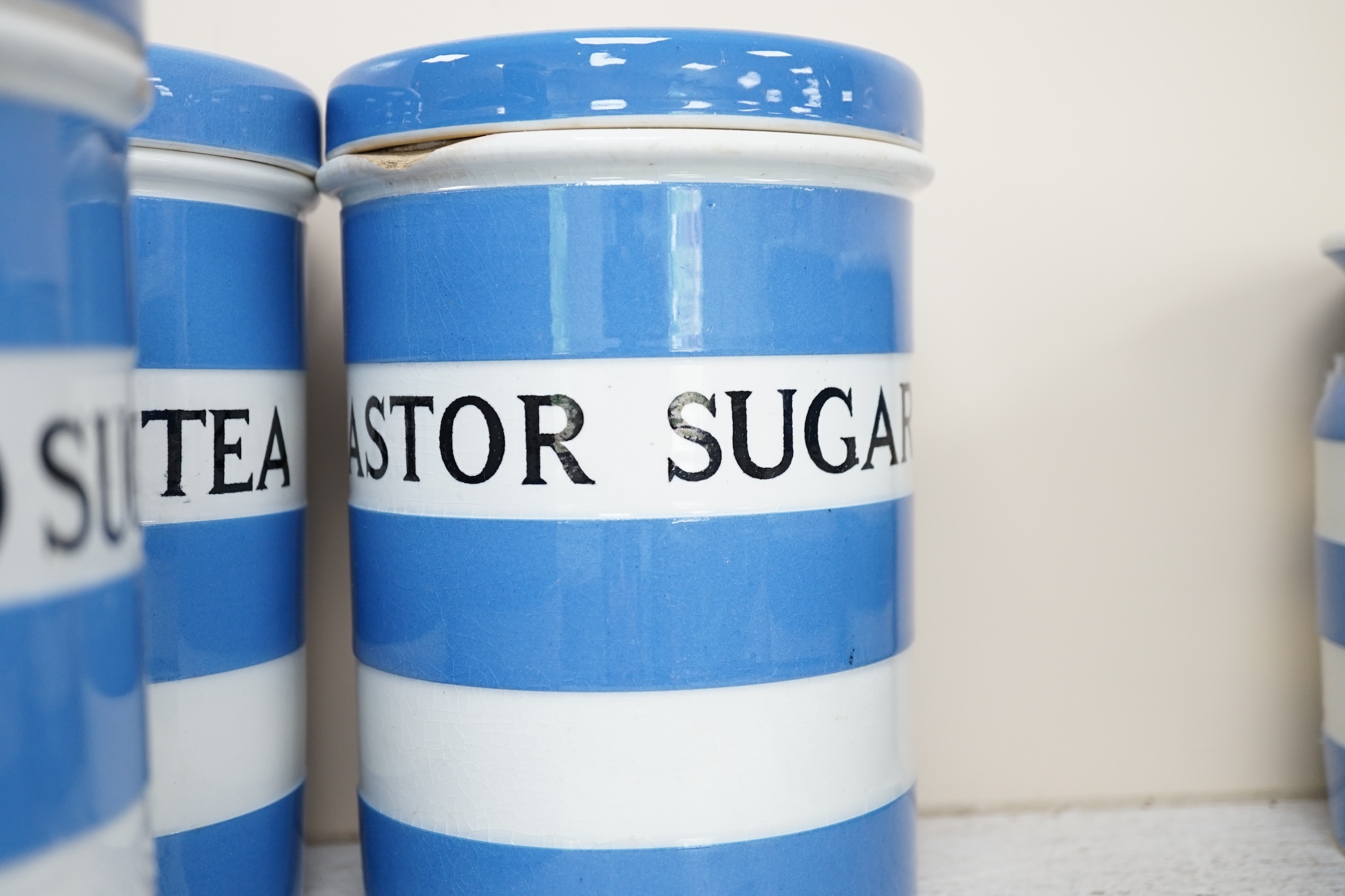 T.G.Green Cornish Kitchenware, eight 17cm lidded storage jars, comprising Currants, Caster Sugar, Granulated Sugar, Indian Tea, Macaroni, Biscuits, Pearl Barley and Quaker, Oats, Black Shield marks. Condition - fair to g